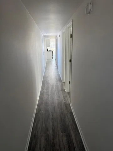 a view of a hallway with wooden floor