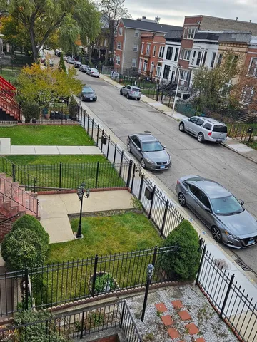 a view of a street with couches and wooden fence