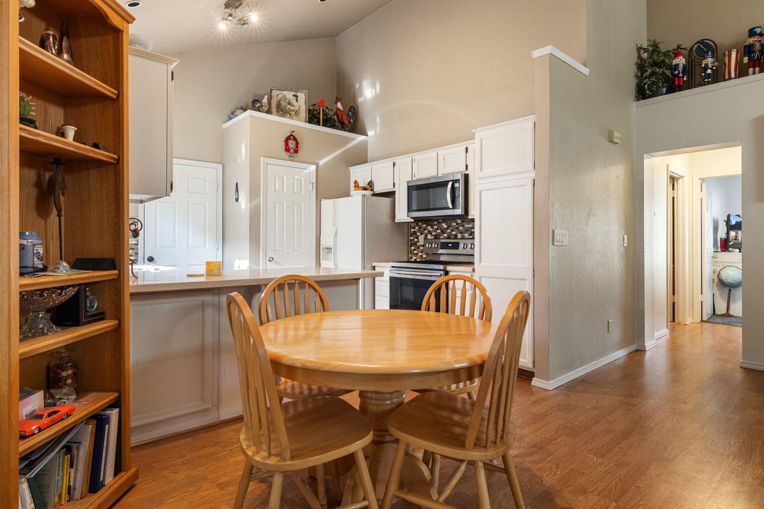 2812 Stone Terrace Modesto, CA 95355 - Photo 18 of 33 a kitchen with stainless steel appliances kitchen island granite countertop a table chairs and a refrigerator
