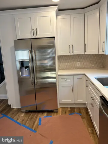 a kitchen with granite countertop white cabinets and white appliances