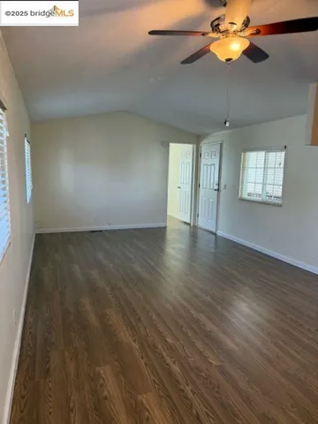 a view of an empty room with wooden floor