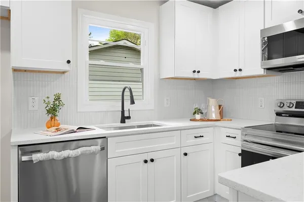 a kitchen with stainless steel appliances white cabinets and a sink