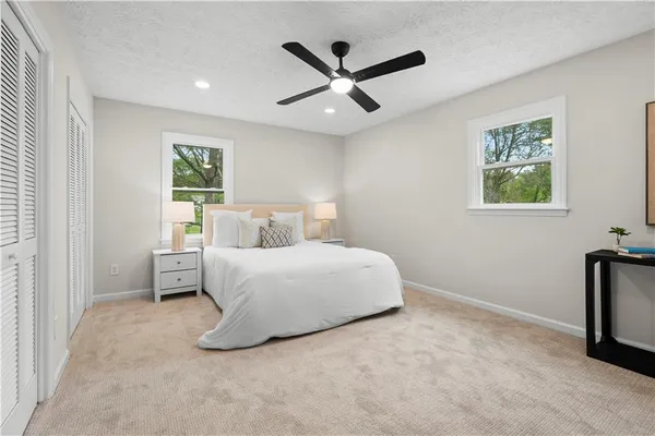 a large bed sitting in a spacious bedroom next to a window and a chandelier