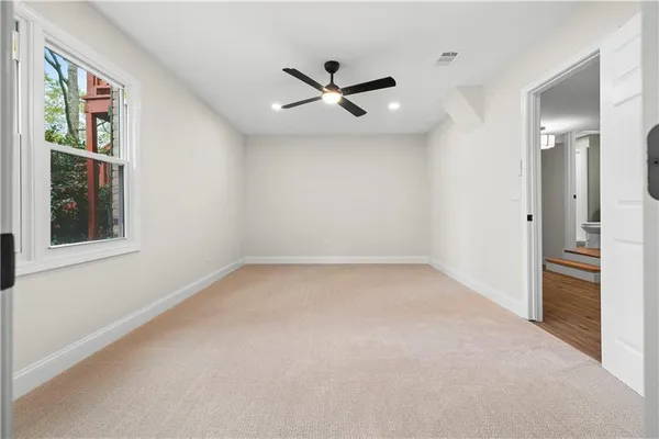an empty room with a window and ceiling fan