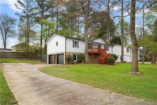 a view of a house with backyard and tree s