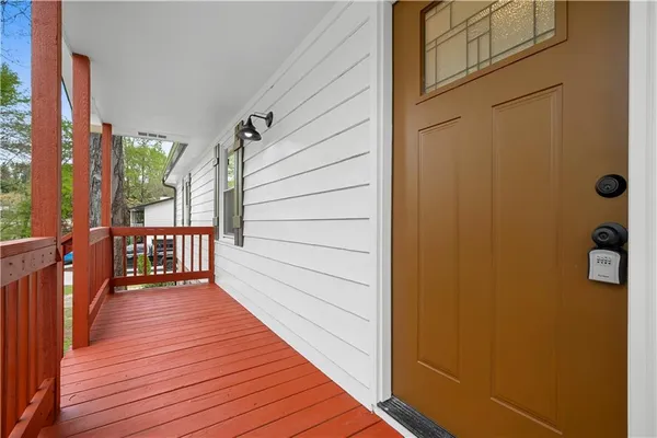a balcony with wooden floor and trees in the back
