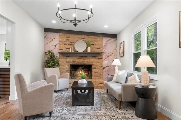 a living room with furniture a fireplace and a large window