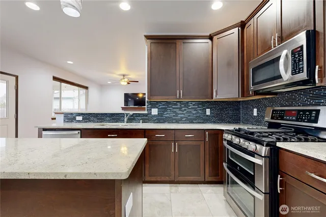 a kitchen with granite countertop a refrigerator and a stove