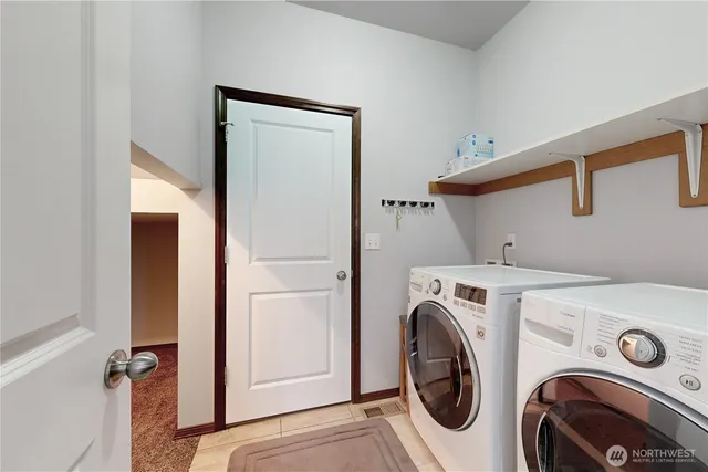 an empty room with windows and view of kitchen