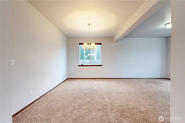 a view of an empty room with window and fireplace