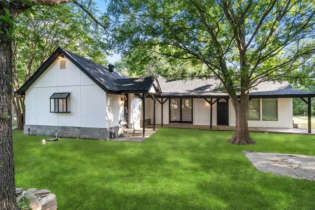 a front view of a house with a garden and yard