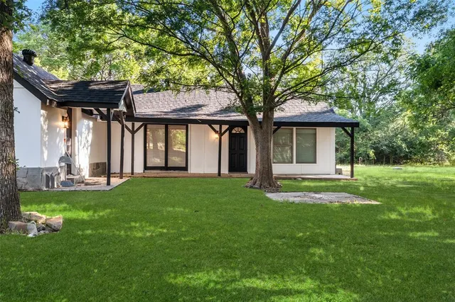 a front view of a house with a garden and yard