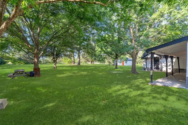 a view of grassy field with benches and trees