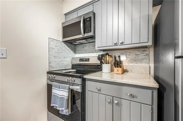 a kitchen with stainless steel appliances granite countertop a sink stove and microwave