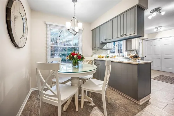 a dining room with chandelier fan and wooden floor