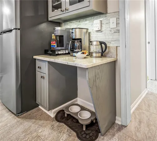 a living room with stainless steel appliances furniture a rug and a view of kitchen