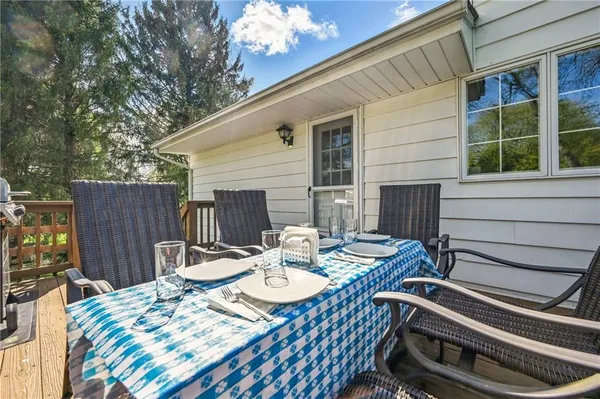 a view of a patio with a table chairs and wooden fence