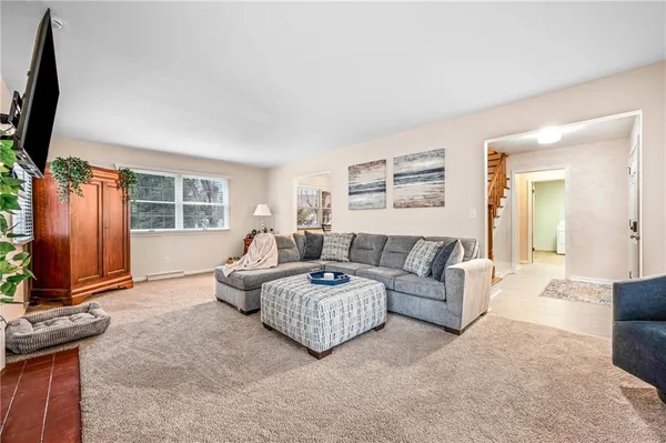 a living room with furniture a window and a flat screen tv