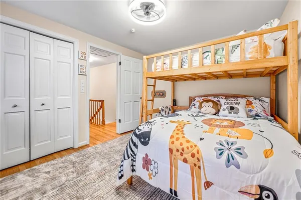 a bedroom with bed and wooden floor