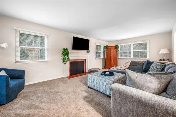 a living room with furniture a flat screen tv and a window