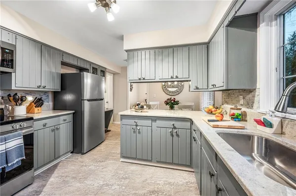 a kitchen with stainless steel appliances granite countertop a sink stove and refrigerator
