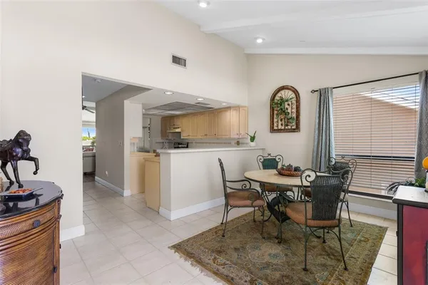 a kitchen with a sink a stove cabinets and a dining table