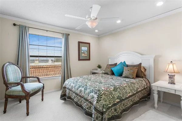 a bedroom with a bed couch and a ceiling fan