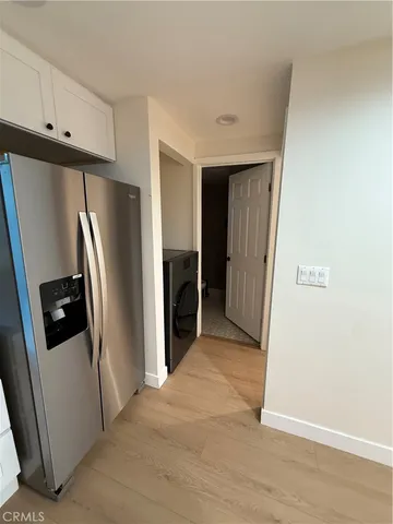 a utility room with washing machine and a view of bedroom