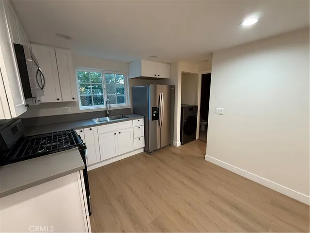a kitchen with a refrigerator stove top oven and sink