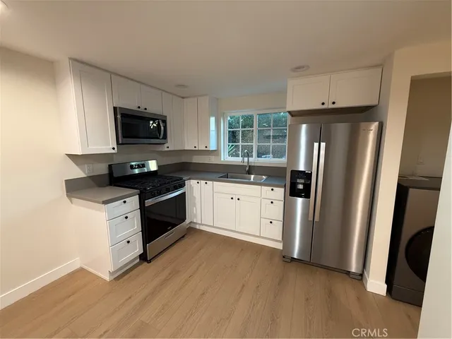 a kitchen with stainless steel appliances a refrigerator stove and microwave