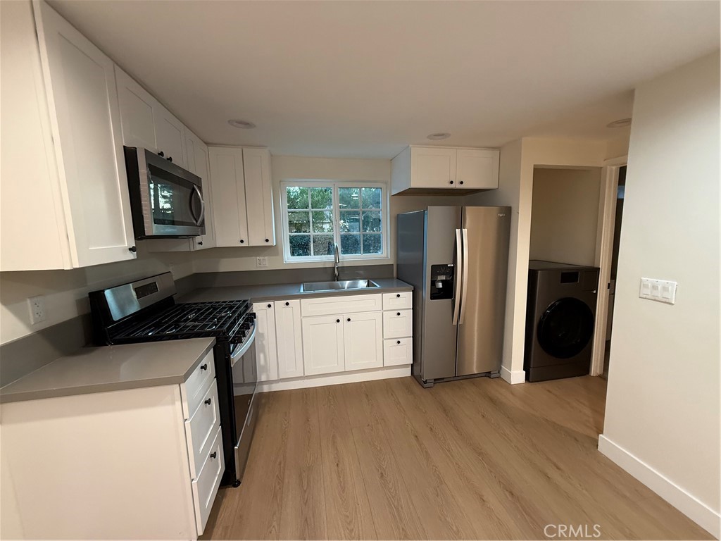 6538 Kelvin Avenue Winnetka, CA 91306 - Photo 10 of 20 a kitchen with a stove a refrigerator and a microwave