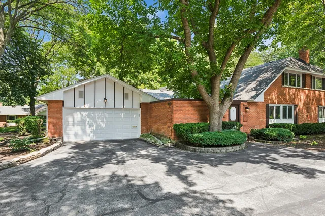 a front view of a house with a yard and trees