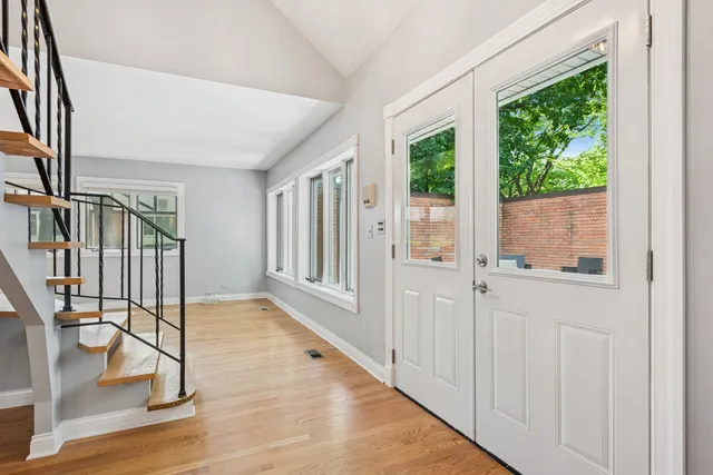 a view of an entryway with wooden floor and door