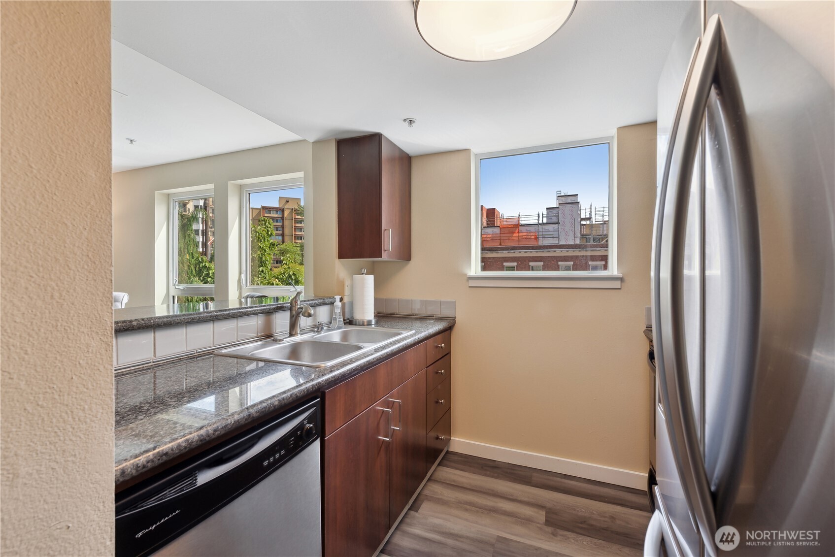 108 5th Avenue South, Unit 506 Seattle, WA 98104 - Photo 9 of 17 a kitchen with stainless steel appliances granite countertop a refrigerator a sink and a stove