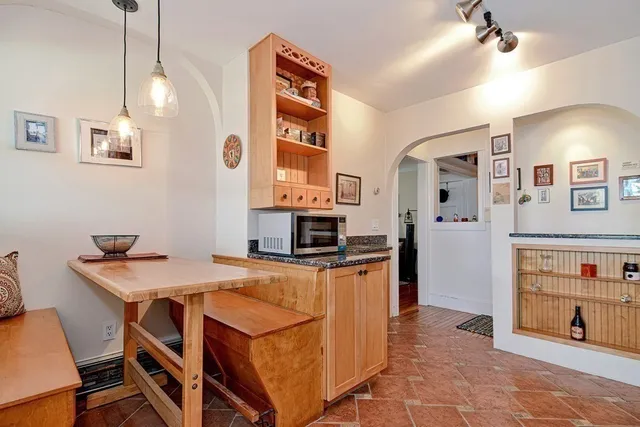 a kitchen with granite countertop a stove a sink dishwasher and a refrigerator with wooden floor