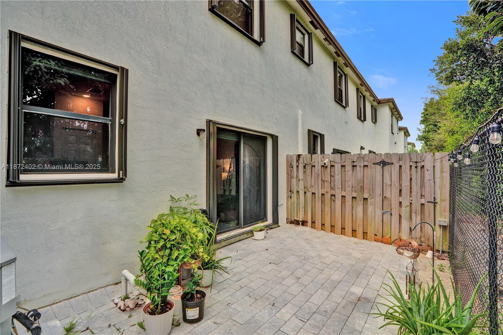 136 Southwest 185th Way Pembroke Pines, FL 33029 - Photo 21 of 48 a house with potted plants in front of door