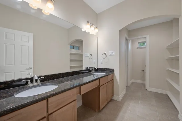 a bathroom with a granite countertop sink double and mirror