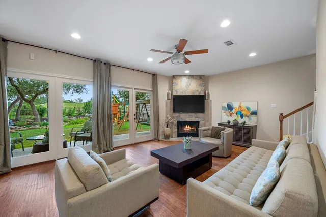 a living room with furniture a flat screen tv and a large window