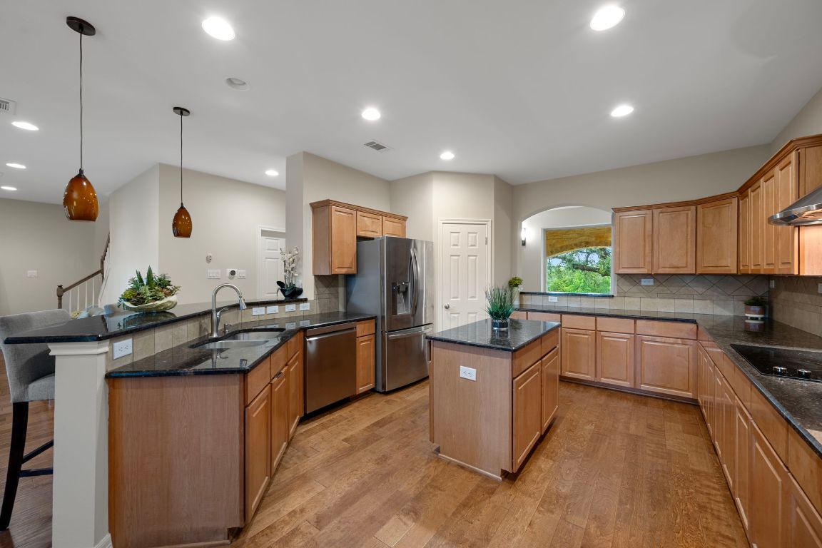 5715 Misty Hill Cove Austin, TX 78759 - Photo 9 of 40 a kitchen with stainless steel appliances granite countertop sink stove and wooden floor