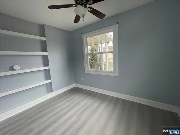 a view of an empty room with a window and a ceiling fan