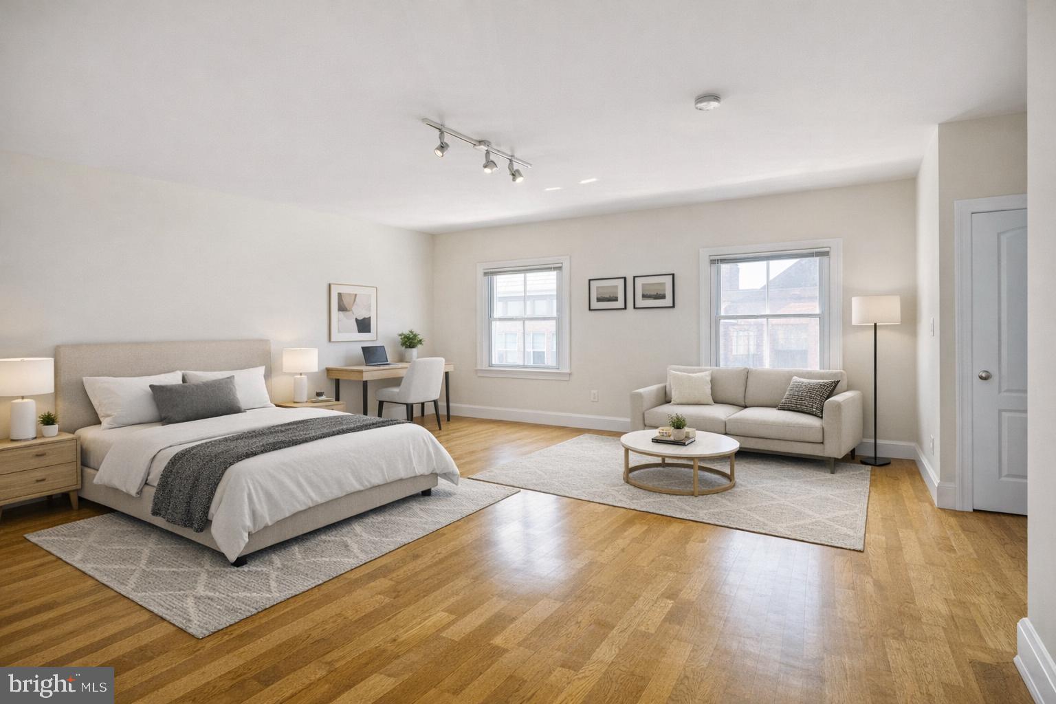 a spacious bedroom with a bed a couch and a window