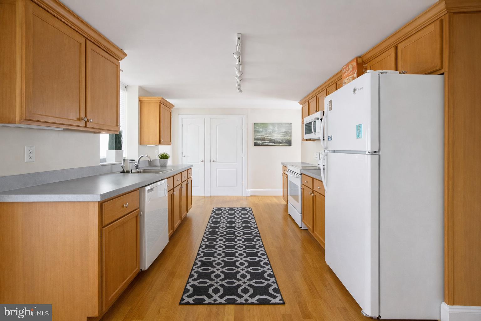 1701-03 Spruce Street, Unit 4F Philadelphia, PA 19103 - Photo 5 of 7 a kitchen with white cabinets and white appliances