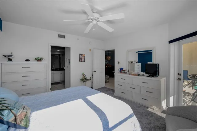 a front view of a building with glass windows and plants