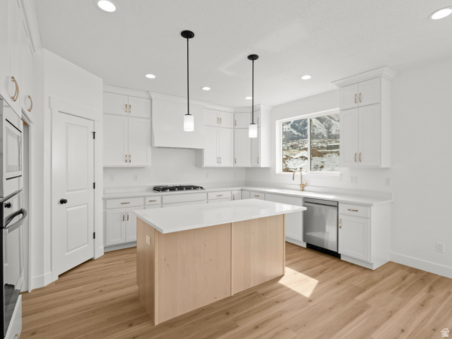 1524 West 1400 North, Unit 2 Mapleton, UT 84664 - Photo 5 of 8 Modern kitchen featuring white cabinetry, a light wood-finish island with a white countertop, stainless steel appliances, and wood-finish flooring
