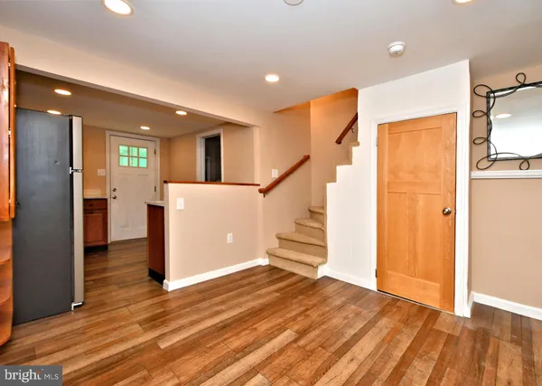 a view of a livingroom with wooden floor and stairs