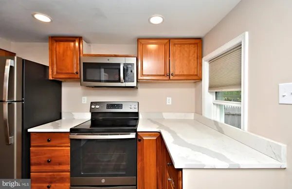 a kitchen with stainless steel appliances granite countertop a refrigerator stove and microwave