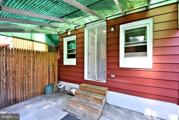 a view of a backyard with a large tree and wooden fence