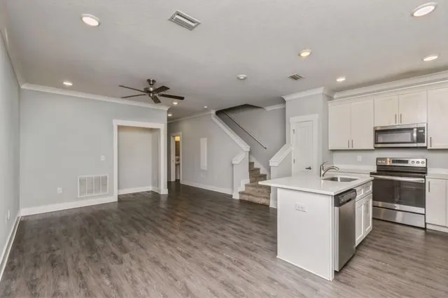 a kitchen with kitchen island a sink appliances and cabinets