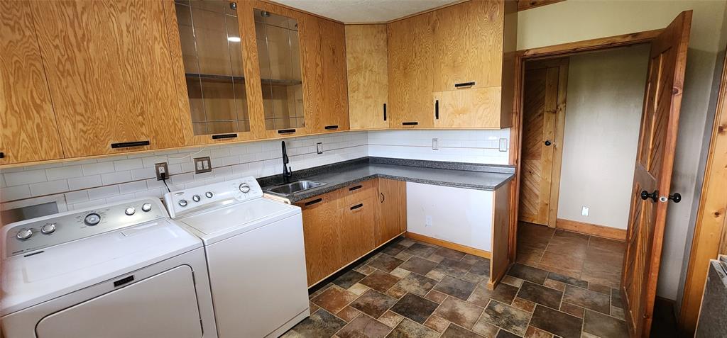 1992 County Road 330 Ranger, TX 76470 - Photo 12 of 40 a utility room with cabinets washer and dryer