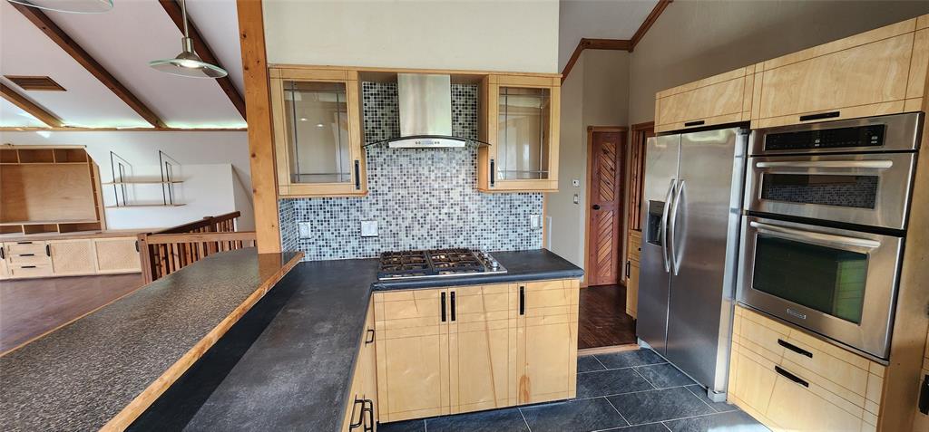 1992 County Road 330 Ranger, TX 76470 - Photo 21 of 40 a kitchen with stainless steel appliances granite countertop a refrigerator a stove and a sink with wooden floor